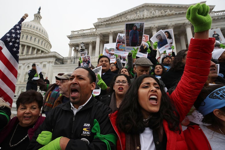 Protesters lock arms and raise fists in front of the Capitol.
